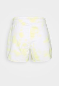 Short blanc avec un motif tie-dye jaune, confectionné dans un tissu doux, affichant un design simple et une ceinture élastique pour le confort.