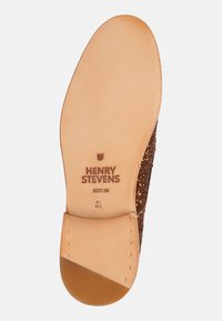 Sole di scarpa marrone glitterata con rivestimento in pelle liscia color tan, nome del brand inciso "HENRY STEVENS BERLIN" e indicatore di taglia "4½".