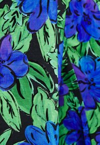 Tissu floral avec de grandes fleurs bleues et des feuilles vertes sur un fond noir. La texture semble lisse avec un léger éclat.