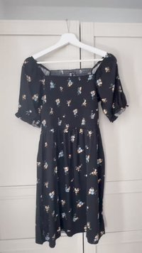 Μαύρο φόρεμα με λουλούδια, κατασκευασμένο από ελαφρύ ύφασμα. Σχέδιο χωρίς ώμους με φουσκωτά μανίκια, που διαθέτει παστέλ σχέδια λουλουδιών και άνετη εφαρμογή.