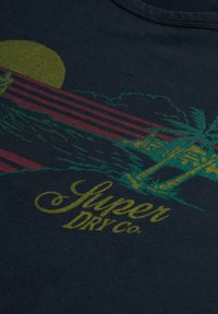 Navyblauwe katoenen T-shirt met een levendig groen en maroon grafisch ontwerp met een zonsondergang, palmbomen en de tekst "Super Dry Co."