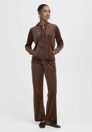 Brauner Velours-Trainingsanzug mit einer Kapuzenjacke mit Reißverschluss und Taschen, passenden Hosen mit lockerer Passform und glatter Textur. Dezenter Glanz sichtbar.
