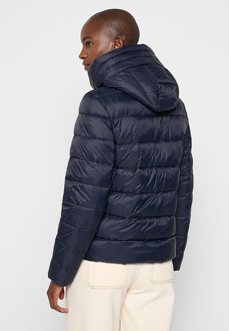 Marineblauer Steppjacke mit Kapuze, die über gesteppte Abschnitte und eine glatte, glänzende Textur verfügt. Entwickelt für Wärme mit einer taillierten Silhouette.