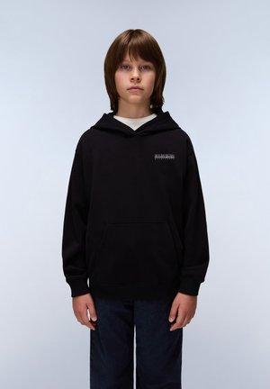 Sudadera negra con un bolsillo frontal y capucha con cordón, presenta un pequeño logo impreso en el pecho. Combinada con pantalones azul oscuro.