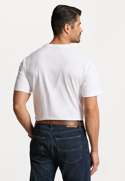 White cotton T-shirt with a crew neck, short sleeves, paired with dark blue denim jeans featuring a brown leather belt and subtle stitching details.