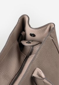 Grau lederne Handtasche innen mit strukturiertem Finish. Verfügt über eine Reißverschluss-Tasche und einen Druckverschluss. Offenes Design mit abgerundeten Kanten.