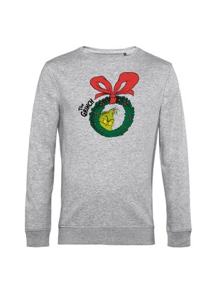Grijze sweatshirt met een grafische print van een groene Grinch in een krans met rode strikaccenten, met de tekst "The Grinch" in het zwart.