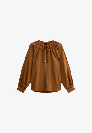 Brun långärmad blus med samlad halsringning, knytdetalj och ballongärmar. Tillverkad av strukturerad tyg med avslappnad passform.