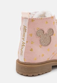 Stivaletto alla caviglia in tessuto rosa con pois dorati e silhouette luccicante di Topolino. Il manico bianco presenta la scritta "Mickey Mouse" in lettere dorate.