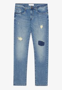 Jean en denim bleu clair avec des zones usées sur les cuisses, fermeture avant à boutons et design cinq poches, posé à plat sur fond blanc.