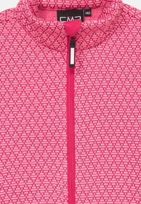 Tüdrukute roosa kudumise jakke geomeetrilise mustriga, täispikk tõmblukk ja püstitatud krae, suuruse silt 140 nähtav.