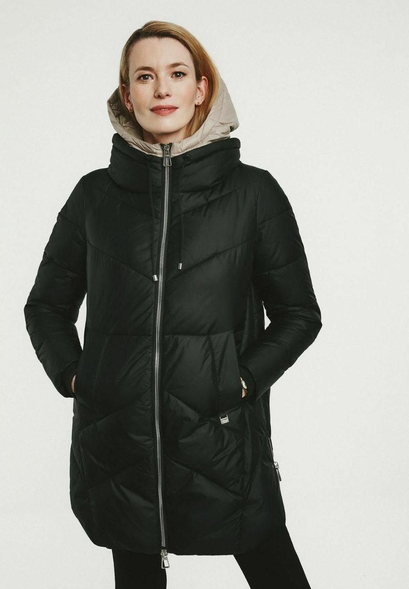 Schwarze Pufferjacke mit glänzender Oberfläche, rautenförmiger Steppung, einer beigefarbenen Kapuze und silbernen Reißverschlusdetails. Verfügt über seitliche Taschen.