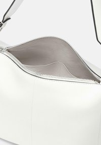 Weiße Lederhandtasche mit Reißverschluss, ausgestattet mit einer glatten Außenseite und beigem Innenfutter. Enthält einen verstellbaren Trageriemen und silberne Hardware.