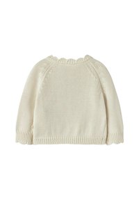 Maglione lavorato a maglia color crema con scollatura a onde e maniche lunghe. Presenta una cucitura testurizzata e una vestibilità ampia. Tessuto semplice e morbido.