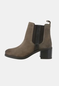 Stivaletti in suede marrone con pannelli elastici laterali, una linguetta e tacco a blocco. Texture liscia con accenti scuri a contrasto.