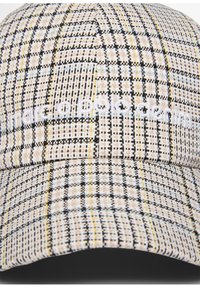 Cap with a checked pattern in beige, black, and blue, featuring textured fabric and embroidered logo on the front.