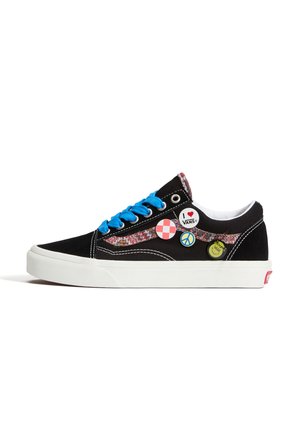 Μαύρο sneaker Vans χαμηλής κορυφής με μπλε κορδόνια, πολύχρωμη πλευρική λωρίδα και τρία διακοσμητικά καρφίτσες στο πλάι κοντά στη φτέρνα.