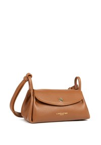 Sac en cuir tan avec une finition texturée, de forme arrondie, fermeture à rabat et une courte poignée. Comprend un logo doré à l'avant.