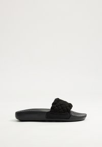 Chanclas negras con textura trenzada en la correa superior, suela lisa y diseño plano adecuado para un uso casual.