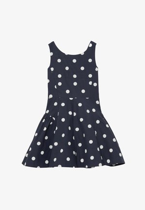 Robe sans manches bleu marine à pois blancs, corsage ajusté et jupe évasée.