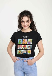 Černé tričko s devíti barevnými Muppet postavami s výraznými obličeji a textem "DNES SE CÍTÍM..." nad nimi. Rovnoběžné rukávy.