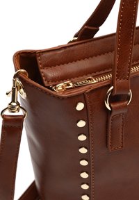 Braune Kunstleder-Handtasche mit goldfarbenen Beschlägen, oberem Reißverschluss und Nietenverzierung entlang einer Seite. Verstellbarer Riemen ist enthalten.