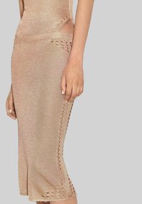 Knit dress in light beige featuring a fitted design, side cutouts, and decorative stitch detailing along the hem and sides.