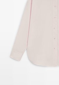 Světle růžová košile s dlouhým rukávem na knoflíky, s manžetami na rukávech a zaobleným lemem na bílém pozadí.