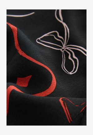 Black fabric featuring abstract white and red patterns, including flowing lines and a bow shape, with a smooth texture.