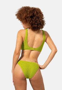 Groene textuur bikini-set met een top met diepe rug en bijpassende low-rise broekjes, met een gekreukeld stofontwerp.