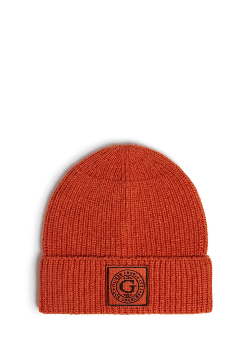 Berretto lavorato a maglia arancione con texture a coste e risvolto. Presenta un'etichetta nera rettangolare con dettagli del logo circolare.
