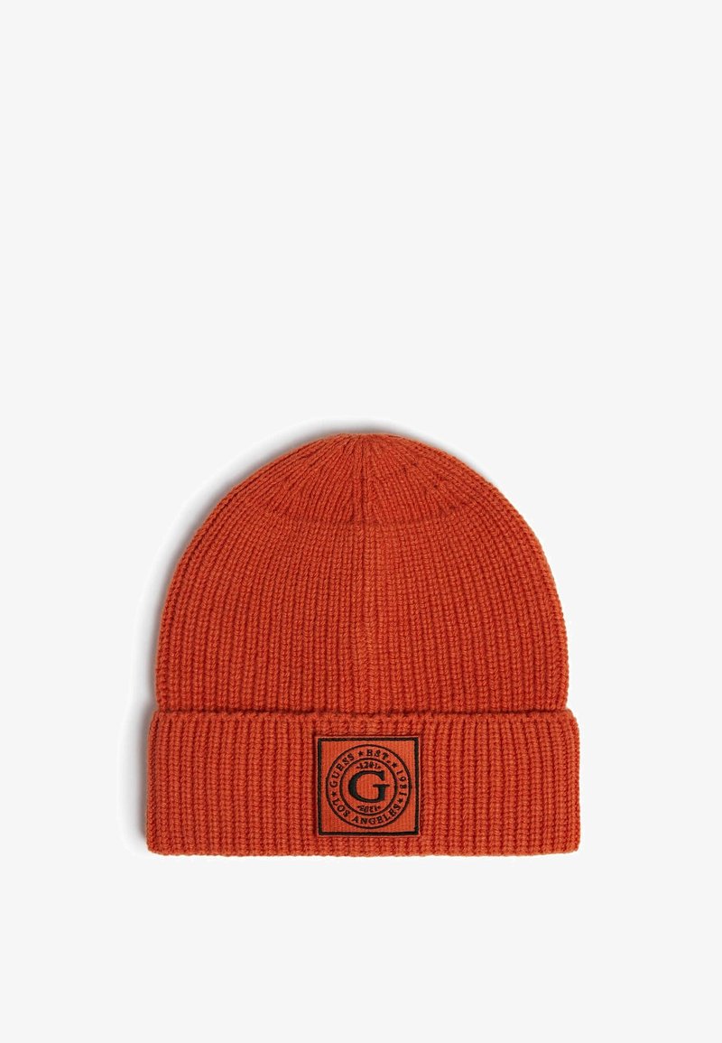 Berretto lavorato a maglia arancione con texture a coste e risvolto. Presenta un'etichetta nera rettangolare con dettagli del logo circolare.