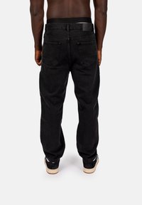 Svarta jeans i denim med en avslappnad passform, raka ben, två bakfickor och en svart midja med logodetalj.