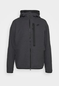 Svart texturerad Nike-jacka med huva, full framdragkedja, ficka med dragkedja på bröstet och diskret logo på vänster bröst.