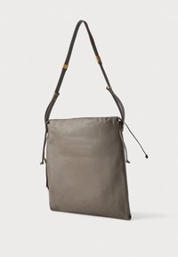 Bolso de hombro de cuero gris con una textura suave, correa ajustable y cierre de cordón. Diseño minimalista sin acentos de hardware visibles.