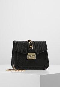 Czarna torebka z ekoskóry z teksturowanym wzorem wężowym, zapięciem ze złotym okuciem oraz łańcuszkowym paskiem. Posiada zapięcie na klapkę i kompaktowy design.