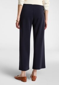 Námořnické široké kalhoty z měkké tkaniny, s hladkým povrchem, jemným strečem a elastickým pasem. Spárovány s hnědými koženými balerínami.