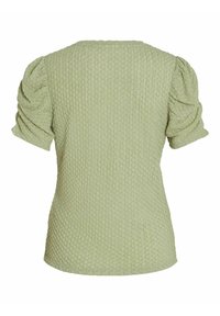 Gestreepte groene blouse met korte pofmouwen en een ronde hals. De stof heeft een verhoogd, stippenpatroon over het geheel.