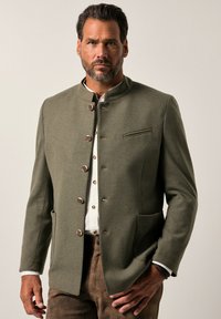 Blazer verde oliva con un cuello alto, botones metálicos, dos bolsillos delanteros y una textura sutil. Corte ajustado, diseñado para uso formal.