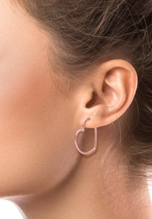 Orecchino a cerchio in oro rosa a forma di cuore, caratterizzato da un design in filo sottile con bordi lisci, indossato all'orecchio.