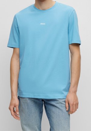 Hellblaues Baumwoll-T-Shirt mit kurzen Ärmeln und Rundhalsausschnitt, mit einem weißen "BOSS"-Logo, das mittig auf der Brust platziert ist. Weicher Stoff.