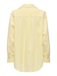 Chemise à manches longues jaune pâle avec poignets boutonnés et dos plissé, présentée sur un fond blanc.