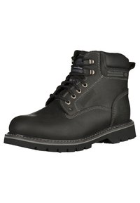 Bota de trabajo de cuero negro con cuello acolchado, ojales de metal y suela de goma gruesa. Presenta detalles cosidos y una puntera reforzada.