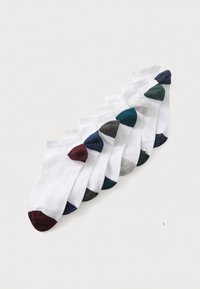 Chaussettes blanches à hauteur de cheville avec des accents de couleur aux orteils en bordeaux, bleu marine, turquoise, gris et vert foncé, disposées en rangée sur un fond clair.
