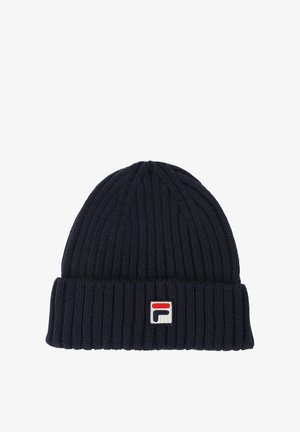 Marinblå ribbad mössa av stickad material med uppvikt fåll. Har ett litet vitt logopatch med röda och blå accenter.