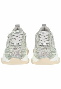 Baskets brillantes argentées et blanches avec une surface texturée, des lacets et une semelle beige. Comprend des strass et un renfort au niveau du talon.