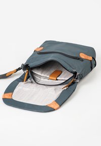 Dark teal bag with tan leather accents, zippered top, and striped interior lining. Features a detachable strap and multiple pockets.