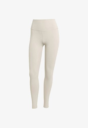 Beige leggings made of stretchy fabric with a high waistband. Smooth texture, form-fitting design, no visible patterns or hardware.