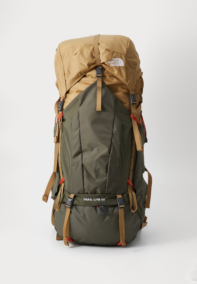 Green and brown nylon backpack with a top lid, adjustable straps, and multiple compartments. Features "TRAIL LITE 65" text on the front.