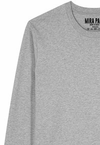 T-shirt gris clair à manches longues en coton avec col rond, étiquette imprimée "MIRA PARIS BORN TO ROCK" et symboles d'entretien à l'intérieur du col.
